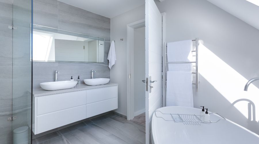 Modern bathroom interior featuring sleek double sink vanity, glass shower, and freestanding bathtub, highlighting contemporary design elements for renovation inspiration.